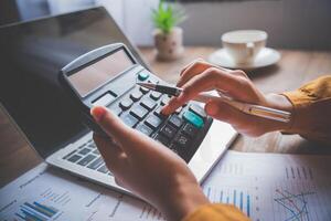 business person sitting at a desk at an office By using the calculator to work. Business Concept Analysis and Planning photo