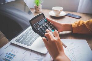 business person sitting at a desk at an office By using the calculator to work. Business Concept Analysis and Planning photo