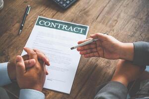 empresario es negociando, asesorando, y explicando el importar de el contrato a ser convenido a firmar el contrato. foto