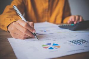 businessman pointing with pen on business report chart are working on accounts in business analysis with graphs and documentation. photo
