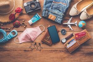 Protecting COVID-19 while Traveling. Travel accessories costumes. Passports, luggage, The cost of travel maps prepared for the trip .concept new normal lifestyle photo