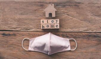 Sanitary napkin mask and the message on the wooden block saying stayhome, the concept of a campaign to prevent the spread of the corona virus photo