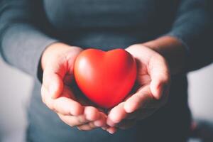 mujer mano participación un corazón símbolo, mundo corazón día, donación, cuidando para caridad, concepto foto