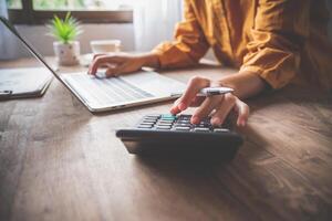 business person sitting at a desk at an office By using the calculator to work. Business Concept Analysis and Planning photo