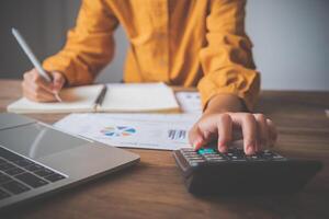 business person sitting at a desk at an office By using the calculator to work. Business Concept Analysis and Planning photo