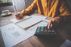 business person sitting at a desk at an office By using the calculator to work. Business Concept Analysis and Planning photo