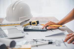 engineer use calculator working in office with blueprints, inspection in workplace for architectural plan, construction project, Business construction photo