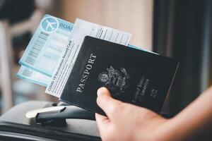 People holding passports and Coronavirus vaccination record card, map for travel with luggage for the trip. Covid-19 around the world photo