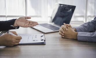 Human resource manager Is explaining the job to the job seeker before filling out a resume on the application form to consider accepting for employment in the company. photo