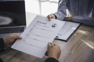 Human resource manager Is explaining the job to the job seeker before filling out a resume on the application form to consider accepting for employment in the company. photo