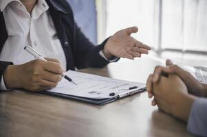Human resource manager Is explaining the job to the job seeker before filling out a resume on the application form to consider accepting for employment in the company. photo