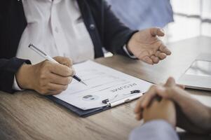 Human resource manager Is explaining the job to the job seeker before filling out a resume on the application form to consider accepting for employment in the company. photo