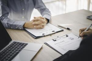 Human resource manager Is explaining the job to the job seeker before filling out a resume on the application form to consider accepting for employment in the company. photo