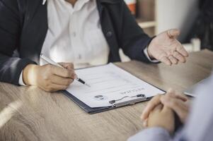 Human resource manager Is explaining the job to the job seeker before filling out a resume on the application form to consider accepting for employment in the company. photo
