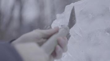 Maestro raspador realiza un movimiento a través de el hielo a crear un hielo escultura. Maestro utilizando especial herramienta a moler abajo formar hielo piezas. hielo composiciones realiza muescas y surcos en el pedazo de video