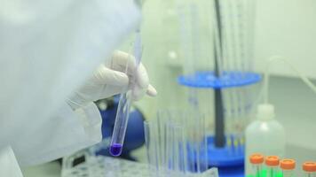 Test tubes closeup. Medical equipment. Close-up footage of a scientist using a micro pipette in a laboratory. Laboratory technician injecting liquid into a microtiter plate. Test tubes. Small depth of video