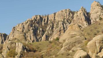 pintoresco paisaje de montañas con verde pequeño arboles en picos en tarde otoño. disparo. hermoso, raro rocas y marchito arbustos en otoño puesta de sol video