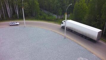 antenn se av läser in lager med semi lastbil. klämma. antenn topp se av lastbilar med frakt semi trailer rör på sig på de väg i de riktning av läser in lager område. antenn se av lastbilar avlastning video