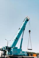 the stove is loaded onto a large blue car crane and prepared for operation . The largest truck crane for solving complex tasks. photo