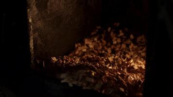 A man puts sawdust in a cast iron furnace close-up. Scene. Man's hands putting wood into the fire close up. Wood furnace. Open firebox with a hardwood log laid inside a furnace. video