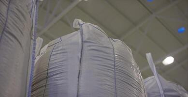 Warehouse for storage of fertilizers in bags. stack of big bag contain rice in warehouse. Big bags video