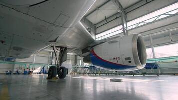 vliegtuig motor in de hangar. vliegtuig turbine detail, vlak in hangar. motor van de vliegtuig onder zwaar onderhoud video