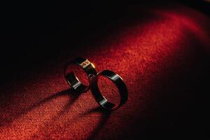 Two wedding rings on a red background. Gold rings of a couple in love.Concept of love.Wedding ring photo