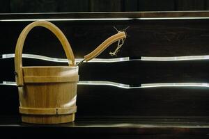 Bucket and ladle in a wooden sauna. Wooden accessories in the sauna photo