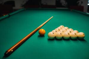 Playing pool on a green table.Balls and cue are laid out on the table photo