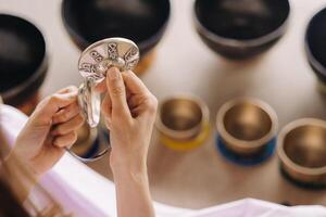 Tibetan singing bowl in your hands - Translation of mantras transform your impure body, speech and mind into a pure exalted body, speech and mind of a Buddha photo