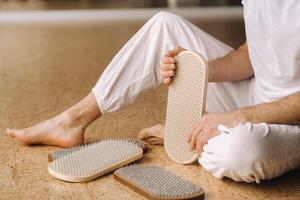 A man holds in his hands boards with nails for yoga classes photo