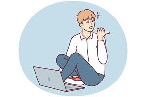 Man sitting on floor with laptop and looking back pointing finger doing online working. Vector image