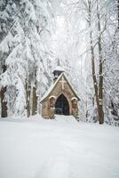 Stone chapel near the famous place Bily Kriz in Beskydy mountains, eastern Czech Republic. Snowfall in winter months photo