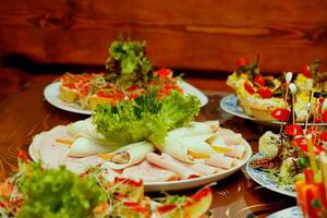 dishes with snacks and greens on the table photo