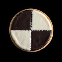 AI generated The classic Black and White cookie, Featuring a soft and cakey base, is artfully divided into quarters, generously coated in rich chocolate icing, and adorned with smooth vanilla fondant photo