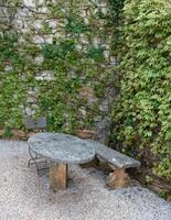Empety table with bench and chair near the castle wall. photo