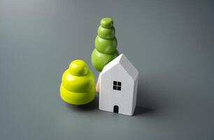 House and decorative trees, figurines. Housing prices. Buying and selling real estate. photo