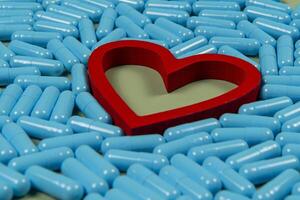 heart shape and blue capsules. Importance of medication treatment photo