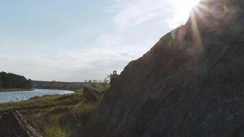 landskap med sten och flod på solnedgång bakgrund. video. pittoresk sjö, bergen och blå himmel. skön landskap med hög stenar med upplyst toppar, stenar i berg sjö, reflexion video