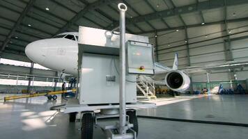 Russia, Moscow - 22 May 2017. Airplane in hangar, rear view of aircraft and light from windows. Business jet airplane is in hangar. The airplane in the hangar, behind the whole plane and the gangway video