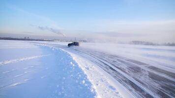 Sport car racing on snow race track in winter. Driving a race car on a snowy road. Track Winter car racing with sun reflection. Race on the track in the winter video