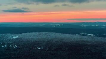 Panoramic view of dramatic sunset in the winter mountains.Beautiful colorful sunset over the snowy mountain range and pine tree forest. Nature landscape. Video. Fog rising from valleys video