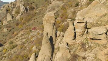 schön Herbst Landschaft mit ungewöhnlich Felsen und Hügel im ein sonnig Tag. Schuss. Berge mit bizarr bilden Spitzen auf verwelkt, Gelb Hügel Hintergrund. video