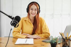 Female podcaster making audio podcast from her home studio photo