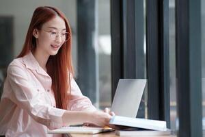 Young collage student using computer and mobile device studying online. photo