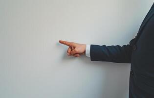 AI generated Professional man in suit pointing at white wall during a presentation or discussion in a modern office setting, brand launch picture photo