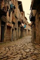 AI generated image captures narrow, cobblestone street lined with old buildings and laundry hanging from the balconies. The sky is overcast, the stone road and buildings Ai Generated photo