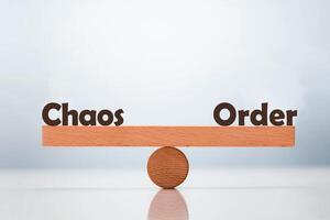 Chaos vs Order word balancing on seesaw choice concept photo