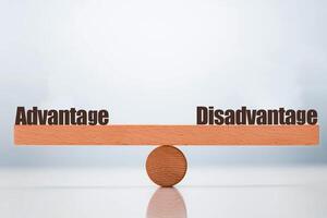 advantage vs disadvantage word balancing on seesaw choice concept photo