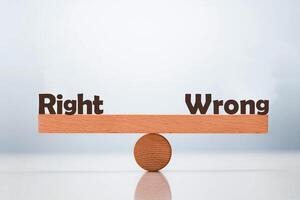 Right vs Wrong word balancing on seesaw choice concept photo